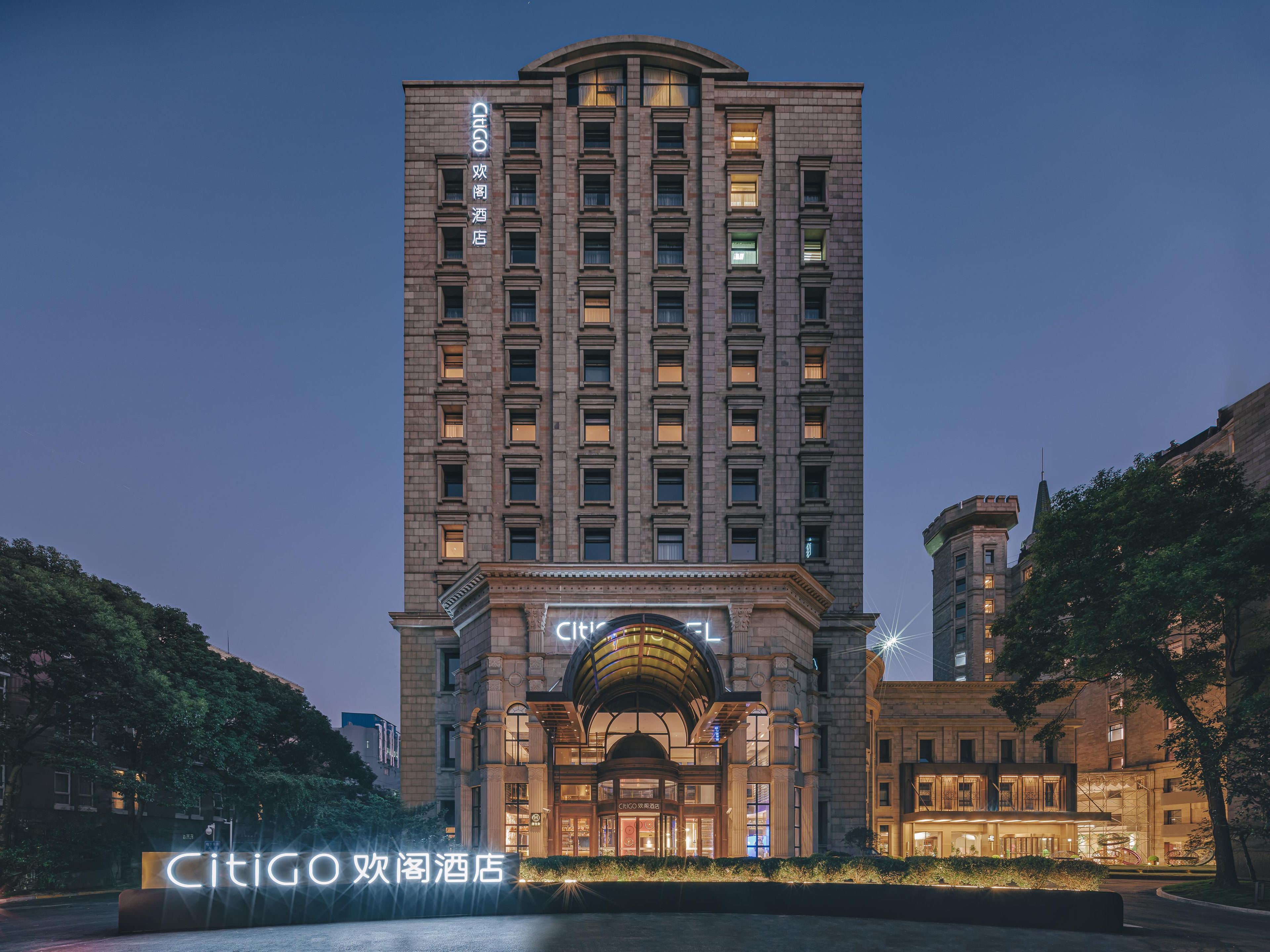 A tall hotel with a classic facade, multiple floors, and a prominent entrance with an arched roof.