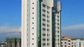 A multi-story building with a modern architectural design, featuring a central glass facade and a series of balconies.