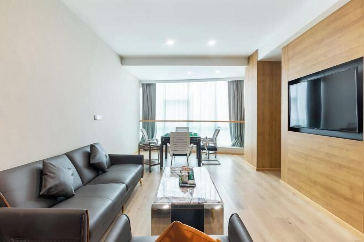 Ein modernes Wohnzimmer mit Sofa, Couchtisch, Fernseher und Essbereich.