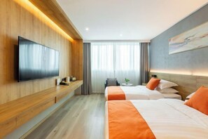 Ein modernes Hotelzimmer mit zwei Betten, einem Flachbildfernseher, einer hölzernen Sitzbank und einem großen Fenster mit Vorhängen.