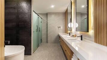 Une salle de bain moderne avec un grand miroir, une baignoire et un meuble-lavabo.