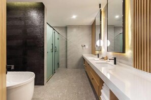 Ein modernes Badezimmer mit einem großen Spiegel, einer Badewanne und einem Waschtisch.