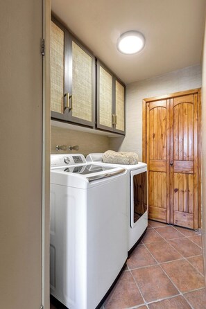 A laundry room with a washing machine, dryer, and wooden door. - Dorado Golf Villa,Pet Friendly (Tucson)