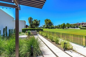 A pathway leading to a building with a pergola, surrounded by greenery and a well-maintained lawn. - Dorado Golf Villa,Pet Friendly (Tucson)