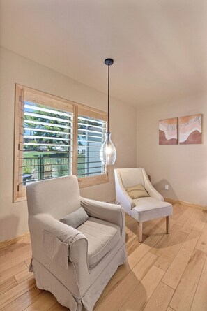 A room with two armchairs, a hanging light fixture, and a window with blinds. - Dorado Golf Villa,Pet Friendly (Tucson)