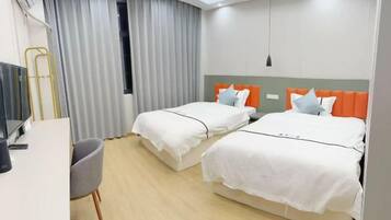 Una habitación de hotel con dos camas, un escritorio, una silla y un televisor.