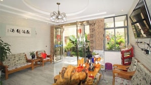 A hotel lobby with a reception desk, seating area, and large windows. - Chenfan Lake View Inn (Dali City)