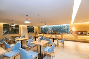 En moderne restaurant med borde, stole, en disk og udsigt over byen.