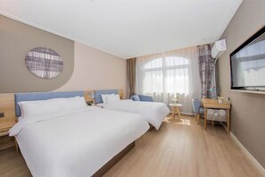 Een hotelkamer met twee bedden, een kleine tafel, een stoel, een televisie en een raam met gordijnen.