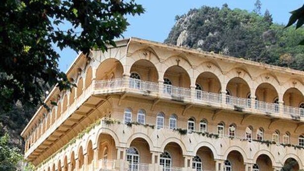 Un edificio de varios pisos con una serie de arcos y balcones, probablemente un hotel o edificio público.