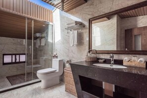 A modern bathroom with a glass-enclosed shower, a white toilet, a dark marble sink, and a large mirror. - Qianbaidu Boutique Inn (Dali City)