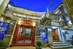 A traditional Chinese gate with intricate carvings and a wooden door. - Qianbaidu Boutique Inn (Dali City)