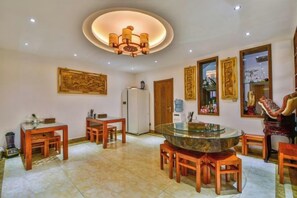 A dining area with a round table, chairs, and a central chandelier. - Qianbaidu Boutique Inn (Dali City)