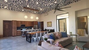 Amplia sala de estar con mesa y sillas de comedor, un sofá y un ventilador de techo.