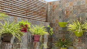 A wall with hanging planters containing various plants.