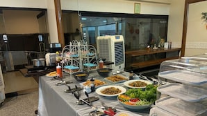 Een buffet met diverse gerechten en bestek.