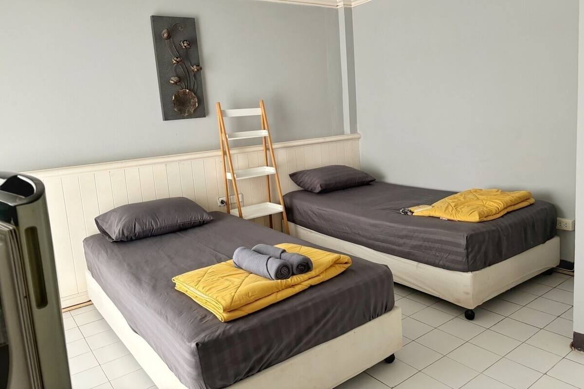 Habitación con dos camas, una escalera y un radiador.