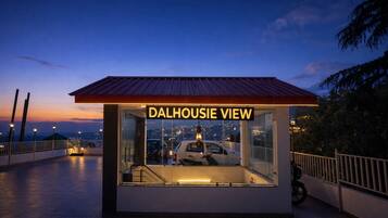 A small, glass-walled structure with a metal roof labeled 'DALHOUSESIE VIEW' and a car parked inside.