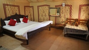 Un dormitorio con una cama grande, una cama más pequeña y una silla.