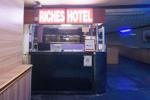 A hotel reception desk with a sign reading 'RICHES HOTEL.' - RedDoorz @ Riches Holiday Hotel Avenida (Manila)