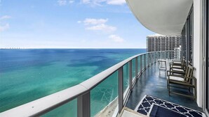 Ein Balkon mit Blick auf das Meer und einen entfernten Steg.