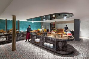 Eine moderne Hotelhalle mit Bar im Zentrum, einer Sitzecke und einer Service-Theke.