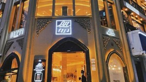 L’entrée d’un hôtel, avec un logo bien visible et un code QR permettant d’accéder au site web.