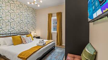 2 habitaciones, escritorio y tabla de planchar con plancha