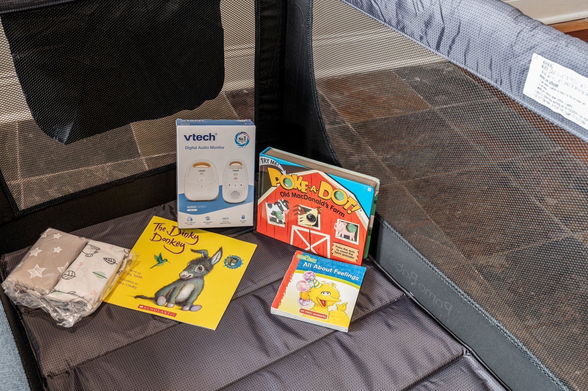 A suitcase with a digital audio player, a book titled 'The Dink's Donkey', and another book titled 'All About Feelings'.