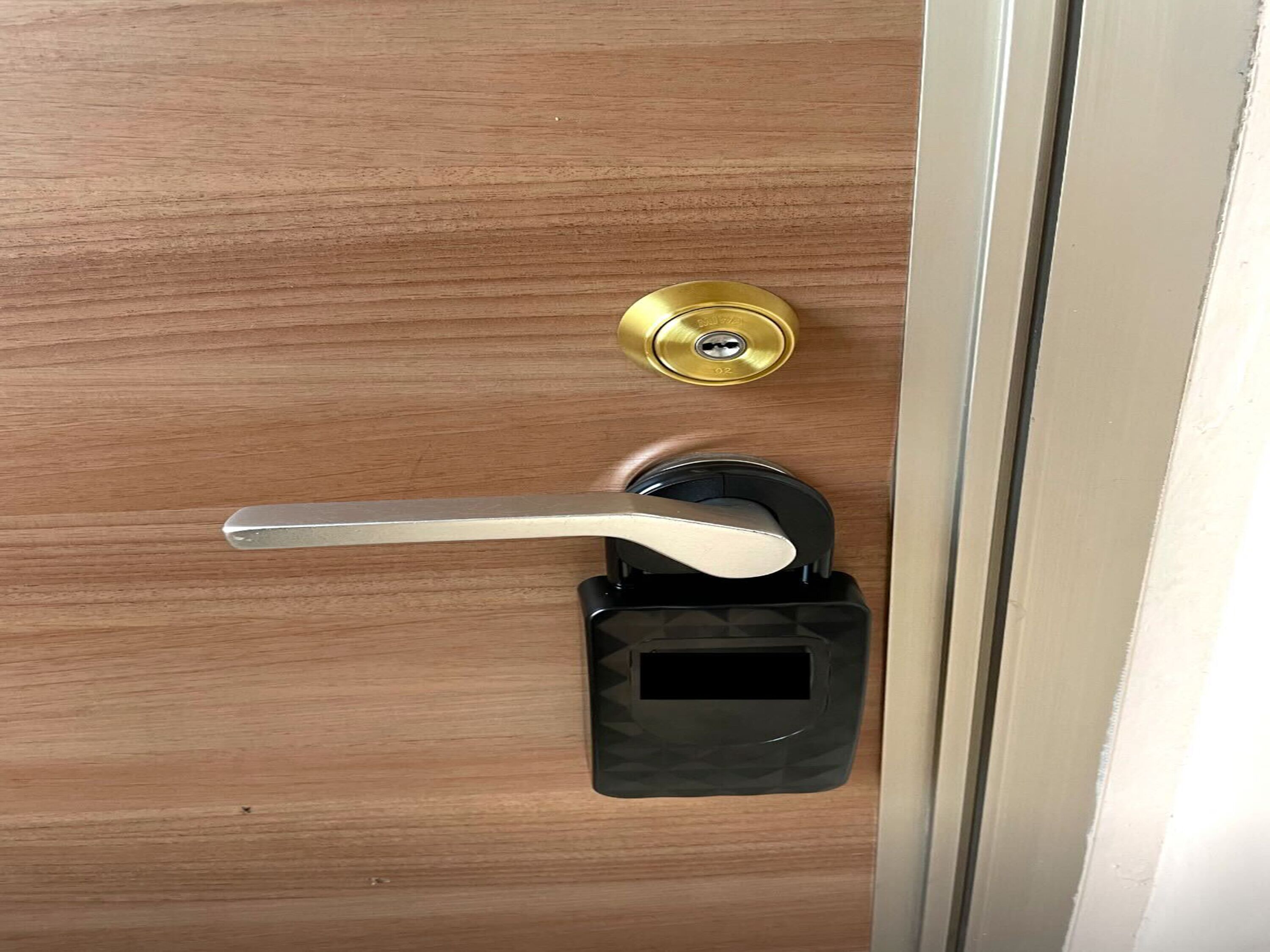 Una puerta con manija negra y cerradura de latón.