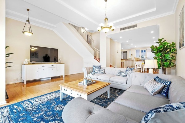A comfortable stay with a large TV, soft seating, and an open layout connecting to the dining and kitchen areas. Easy access to upstairs via the staircase.