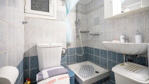 Un baño con inodoro, ducha y lavamanos.