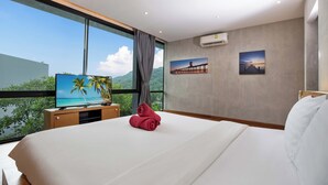 Ein modernes Hotelzimmer mit einem großen Bett, einem Fernseher und schöner Aussicht durch das Fenster.