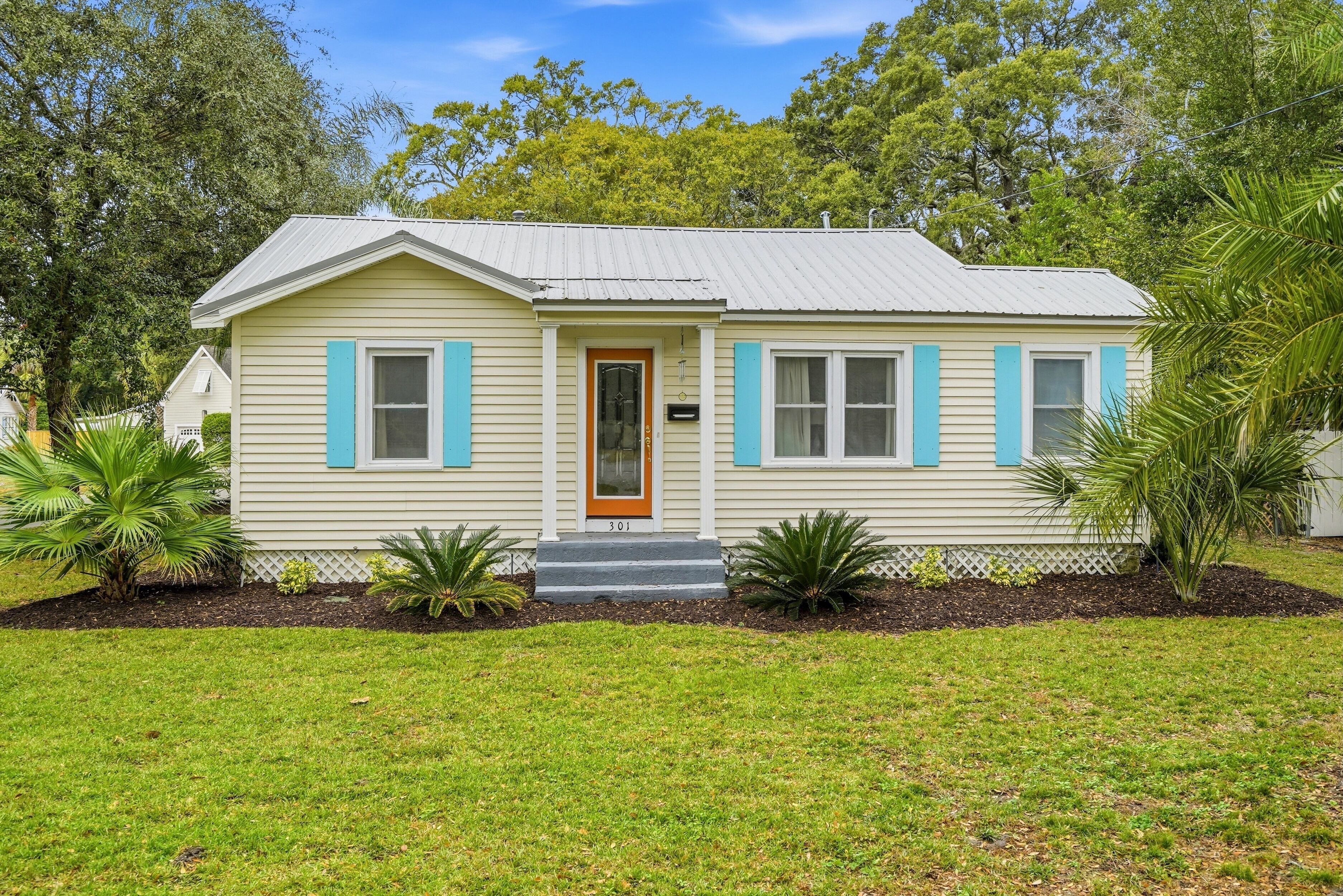 A single-story house with a front door, a small porch, and a mailbox.