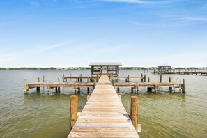 Un muelle de madera que lleva a un embarcadero con un pequeño refugio al final.