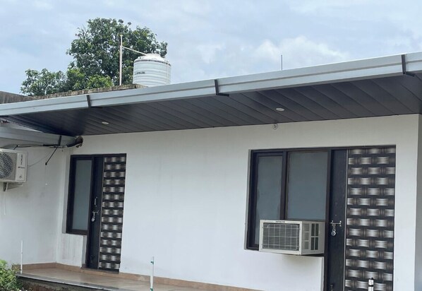 Un edificio moderno con dos puertas, una con una celosía metálica y la otra con un diseño ornamental.