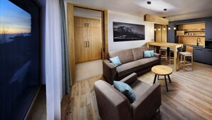 A modern living room with a sofa, coffee table, and a stone fireplace. - APLEND Monte Móry (Štrba)