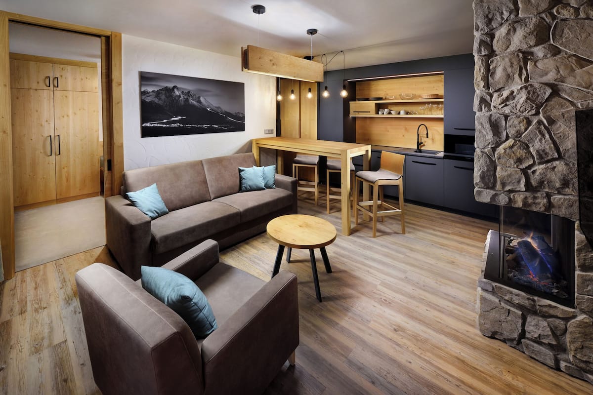 Una sala de estar moderna con un sofá, una mesa de centro y una chimenea de piedra.