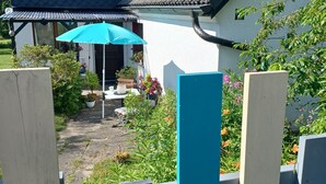 A house with a dark roof, a white exterior, and a blue fence in the foreground. - Vacation apartment for 2 near Spreewald & Schlaubetal - quiet location  (Lieberose)