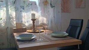 A dining area with a table set for two, featuring a candle, wine glasses, and decorative plates. - Vacation apartment for 2 near Spreewald & Schlaubetal - quiet location  (Lieberose)