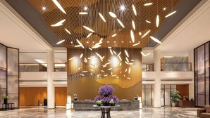 A spacious lobby with a high ceiling, modern lighting fixtures, and a central floral arrangement. - Wyndham Zhangjiajie Wulingyuan (Zhangjiajie)