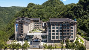 A multi-story hotel with a traditional architectural design, featuring a central courtyard and multiple balconies. - Wyndham Zhangjiajie Wulingyuan (Zhangjiajie)