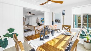 A dining area with a wooden table, chairs, and a ceiling fan.