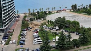 Ein Hotel an der Küste mit Parkplatz, Strand und Meerblick.