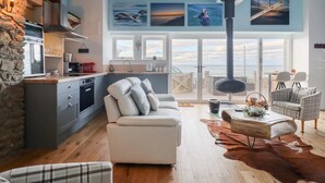 Una cocina moderna con pared de piedra, un comedor con vistas y una zona de estar acogedora con chimenea.