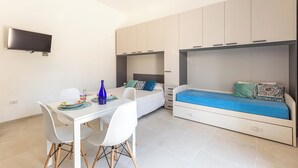 Ein gemütliches Schlafzimmer mit Bett, Schreibtisch und Fernseher.
