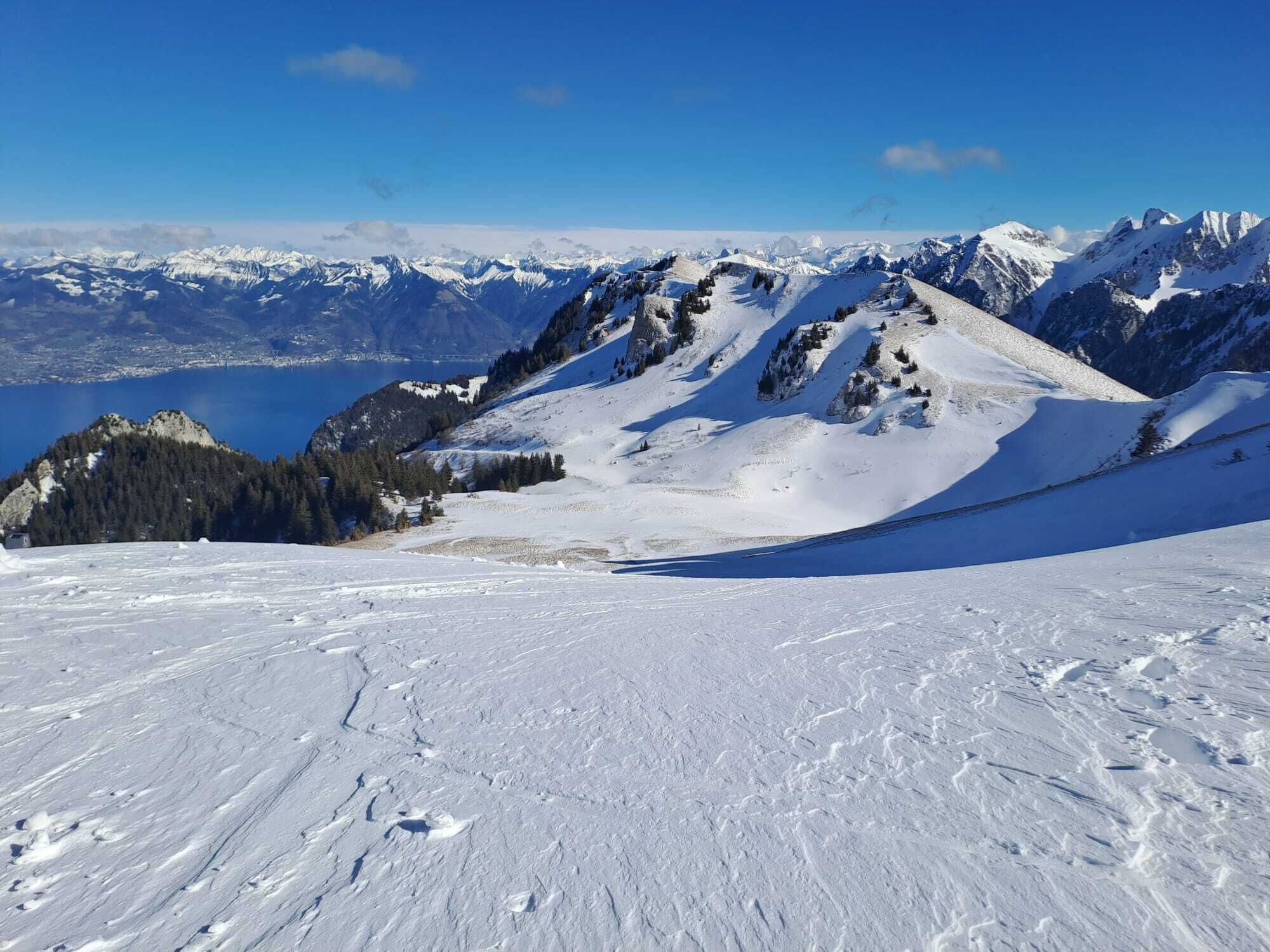 Un paysage de montagne enneigé, sous un ciel dégagé.