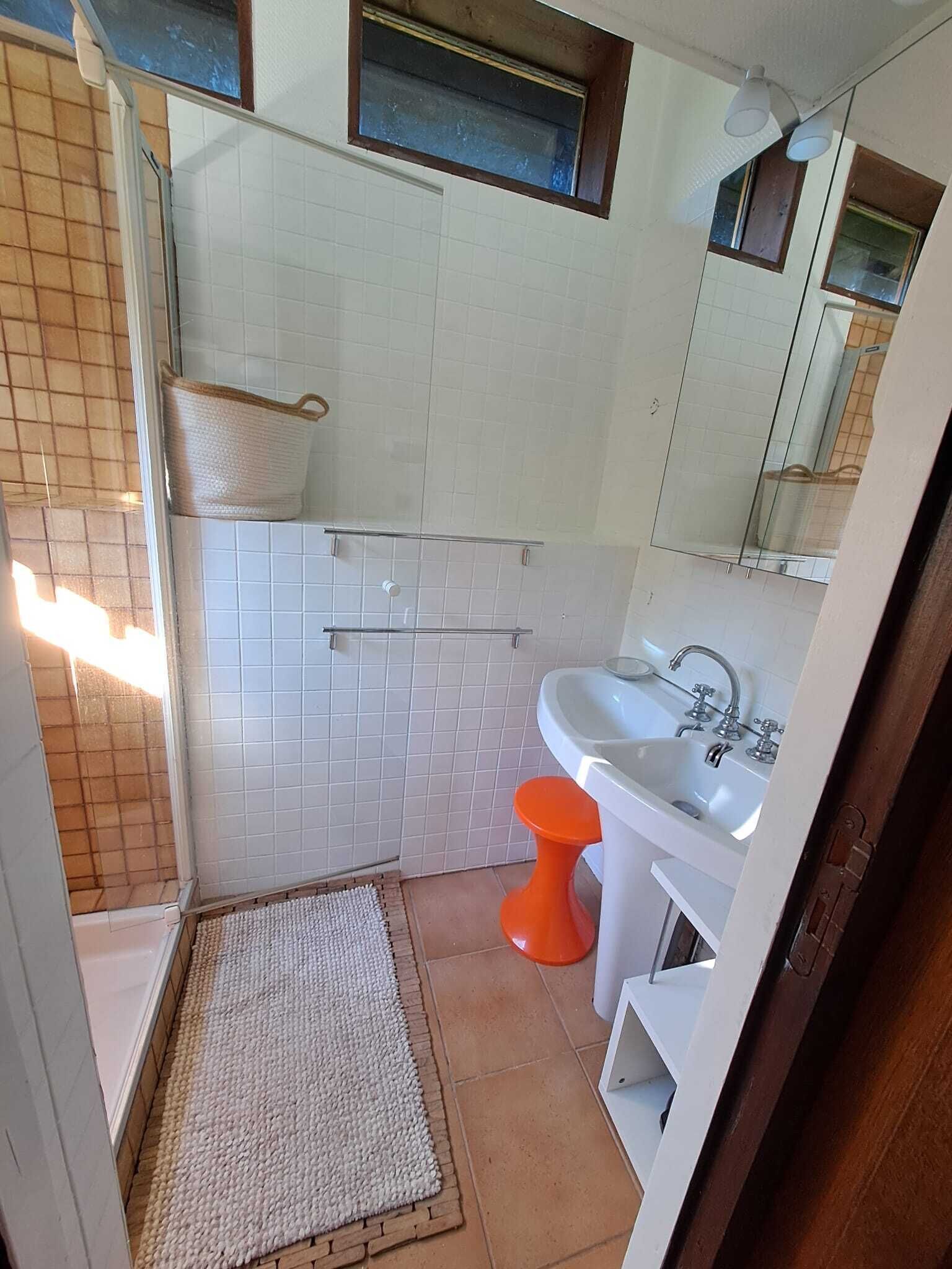 Ein Badezimmer mit Dusche, Toilette, Waschbecken und Spiegel.