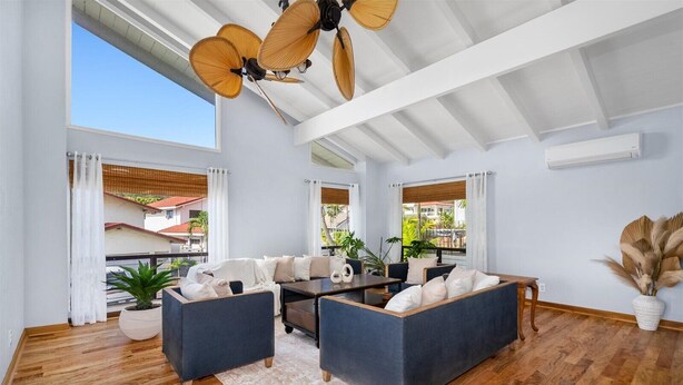 Ein modernes Wohnzimmer mit einer Sofagarnitur, einem Couchtisch und einem Deckenventilator.