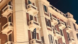 Un hôtel à plusieurs étages, doté de balcons et d’une enseigne indiquant qu’il s’agit d’un hôtel.